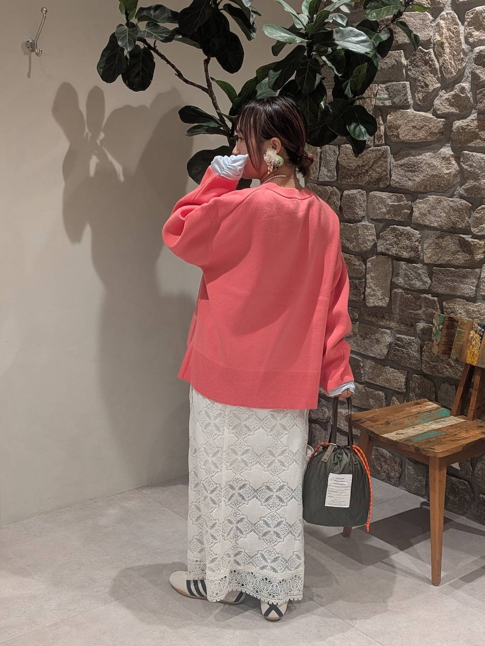 ホワイト系のスニーカー、グリーン系のショルダーバッグ、ピンク系のニット/セーターを着用したレディースの冬コーディネートの3枚目の写真