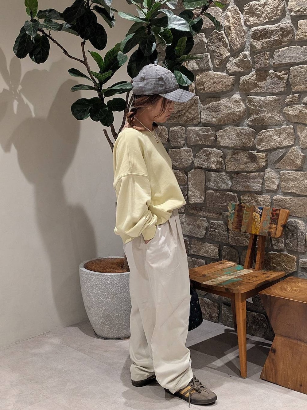 ブラウン系のスニーカー、ブラック系のハンドバッグ、イエロー系のスウェットを着用したレディースの秋コーディネートの2枚目の写真