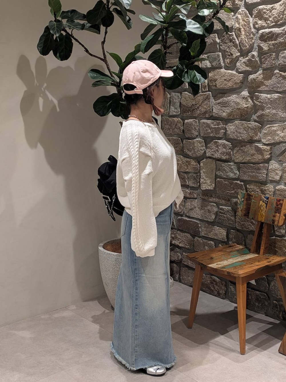 グレー系のスニーカー、ブルー系のデニムスカート、ブラック系のバックパック/リュックを着用したレディースの冬コーディネートの3枚目の写真