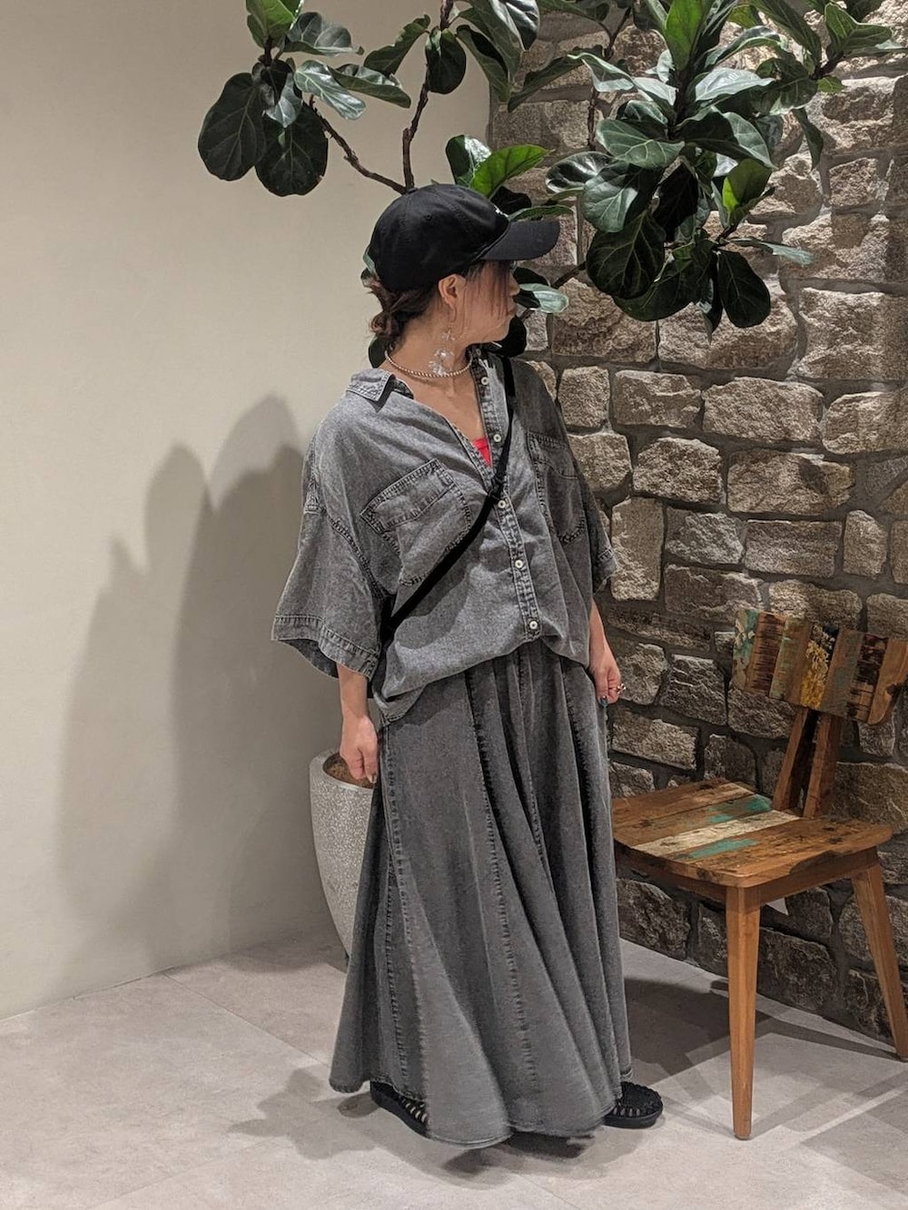 ブラック系のショルダーバッグ、グレー系のシャツ/ブラウス、レッド系のタンクトップを着用したレディースの春コーディネートの2枚目の写真