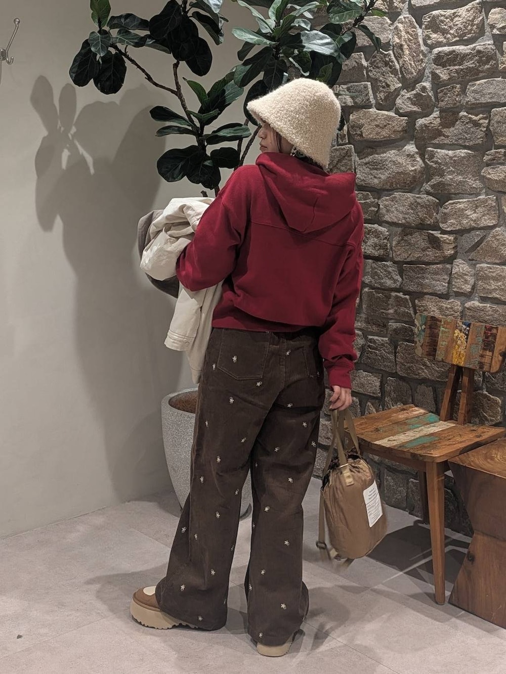 ブラウン系のその他パンツ、レッド系のパーカー、ベージュ系のショルダーバッグを着用したレディースの冬コーディネートの5枚目の写真