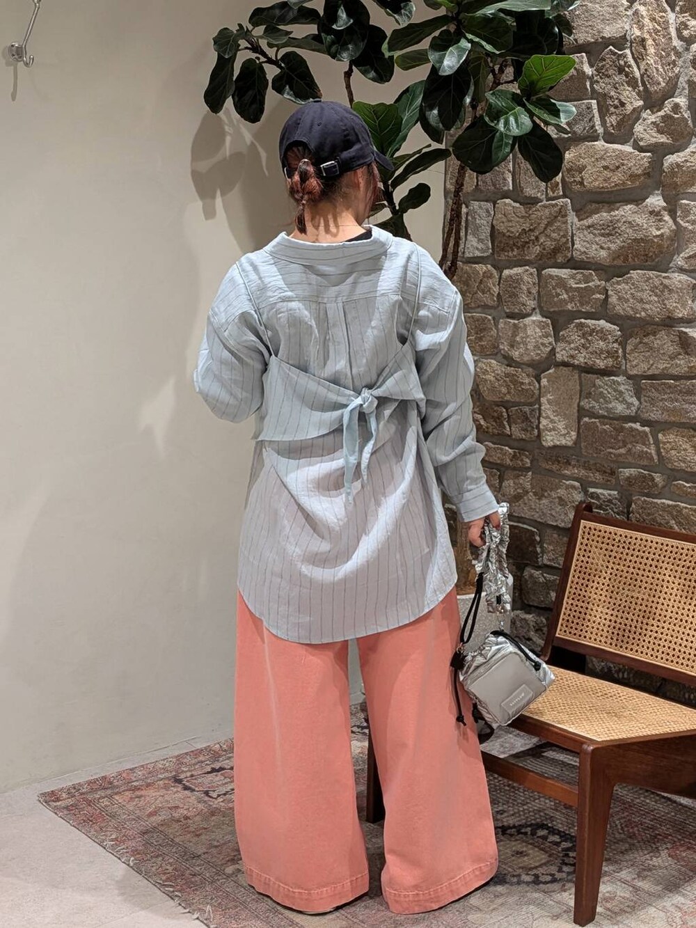 ブルー系のスニーカー、シルバー系のショルダーバッグ、ピンク系のデニムパンツを着用したレディースの冬コーディネートの2枚目の写真