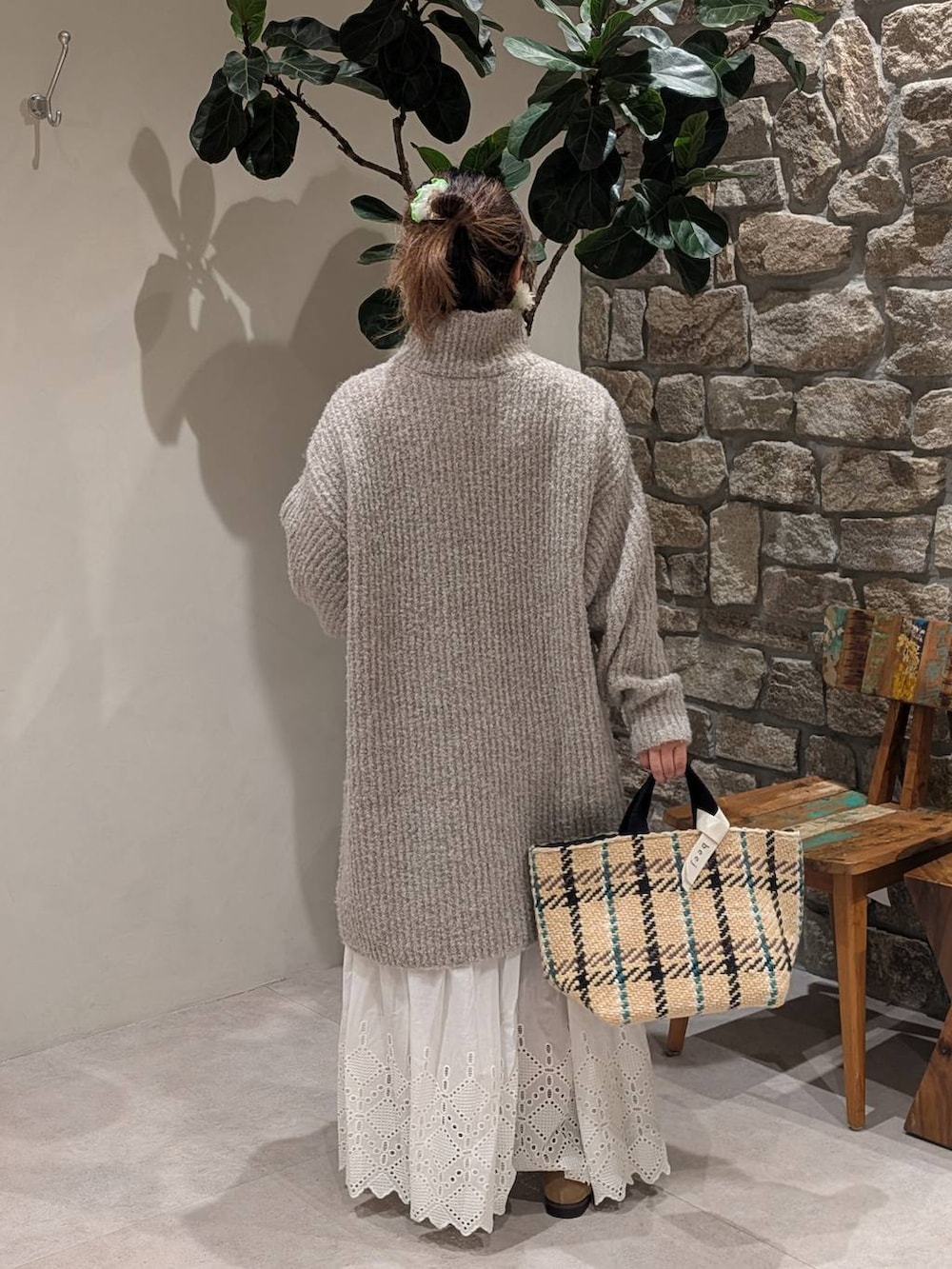 ベージュ系のトートバッグ、ベージュ系のモカシン/デッキシューズ、ホワイト系のスカートを着用したレディースの秋コーディネートの3枚目の写真