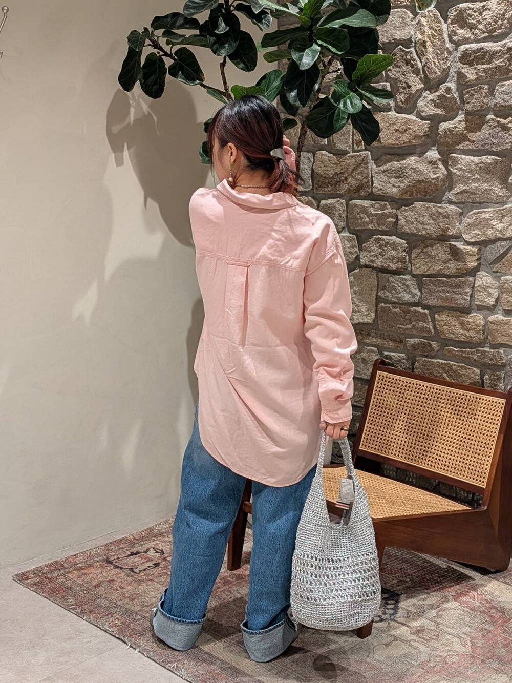 シルバー系のバレエシューズ、ピンク系のシャツ/ブラウス、ブルー系のデニムパンツを着用したレディースの冬コーディネートの2枚目の写真