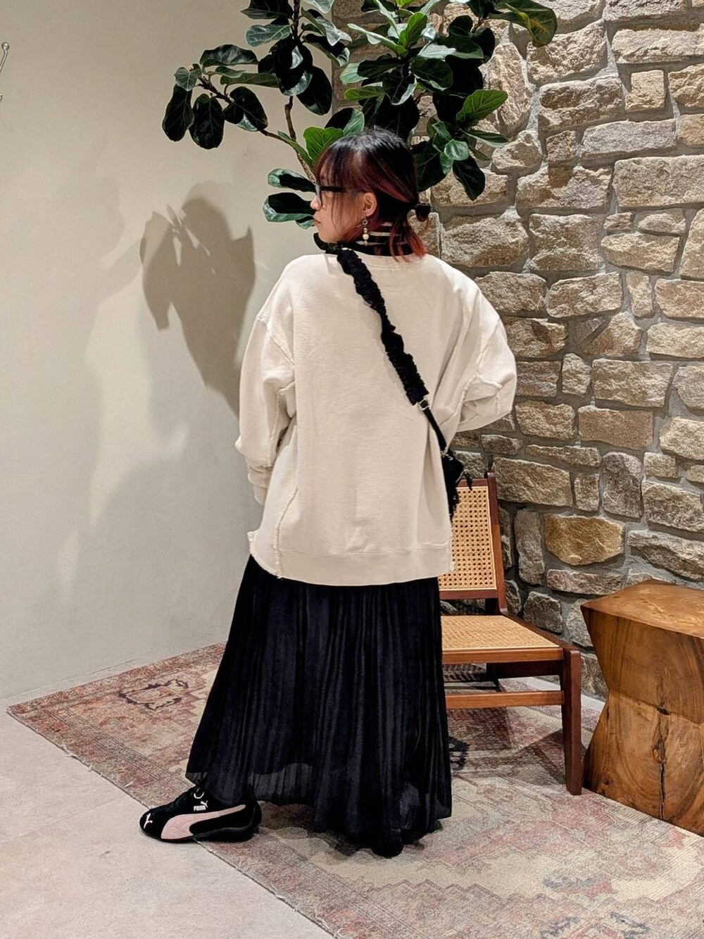 ブラック系のニット/セーター、ブラック系のショルダーバッグ、ブラック系のスカートを着用したレディースの冬コーディネートの3枚目の写真