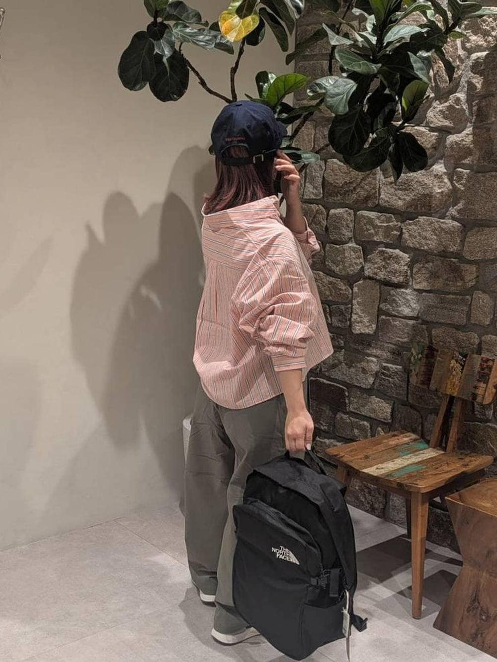 ブルー系のスニーカー、オレンジ系のシャツ/ブラウス、ブラック系のバックパック/リュックを着用したレディースの春コーディネートの3枚目の写真