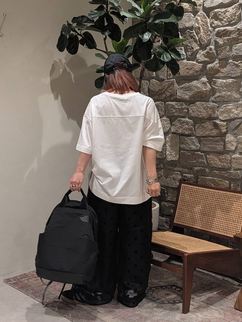 ブラック系のバックパック/リュック、ブラック系のスニーカー、ブラック系のその他パンツを着用したレディースの春コーディネートの2枚目の写真