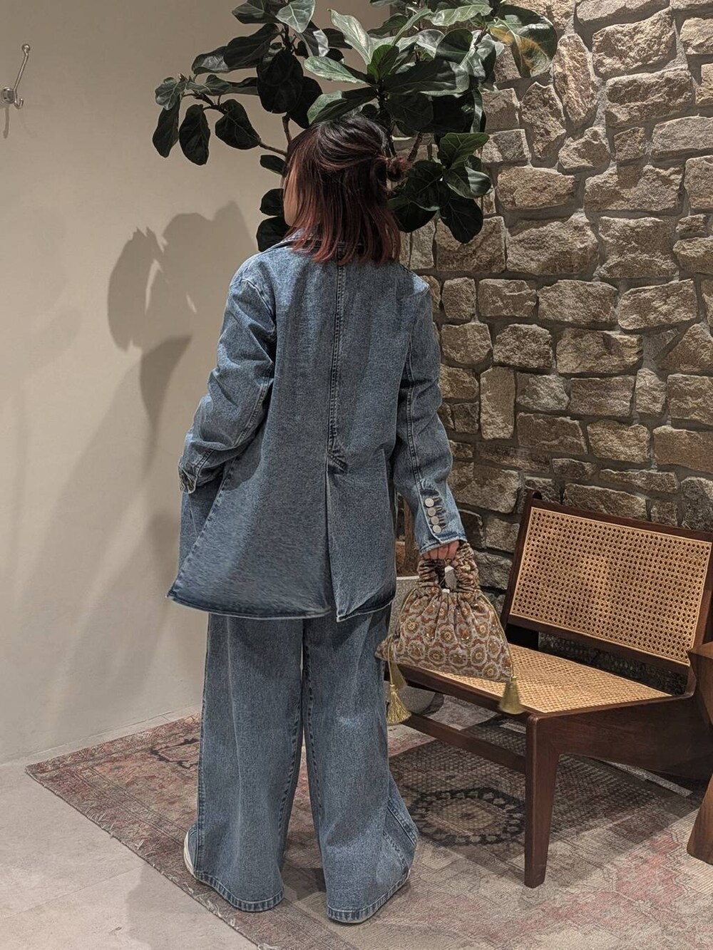 グレー系のハンドバッグ、ホワイト系のスニーカー、ホワイト系のTシャツ/カットソーを着用したレディースの冬コーディネートの2枚目の写真