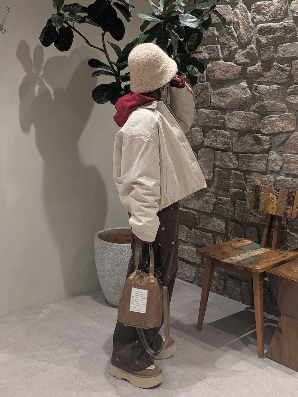 ブラウン系のその他パンツ、レッド系のパーカー、ベージュ系のショルダーバッグを着用したレディースの冬コーディネートの3枚目の写真