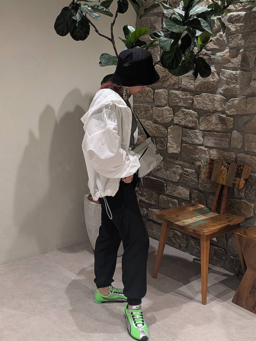 グレー系のショルダーバッグ、ブラック系のその他パンツ、ホワイト系のブルゾンを着用したレディースの春コーディネートの2枚目の写真