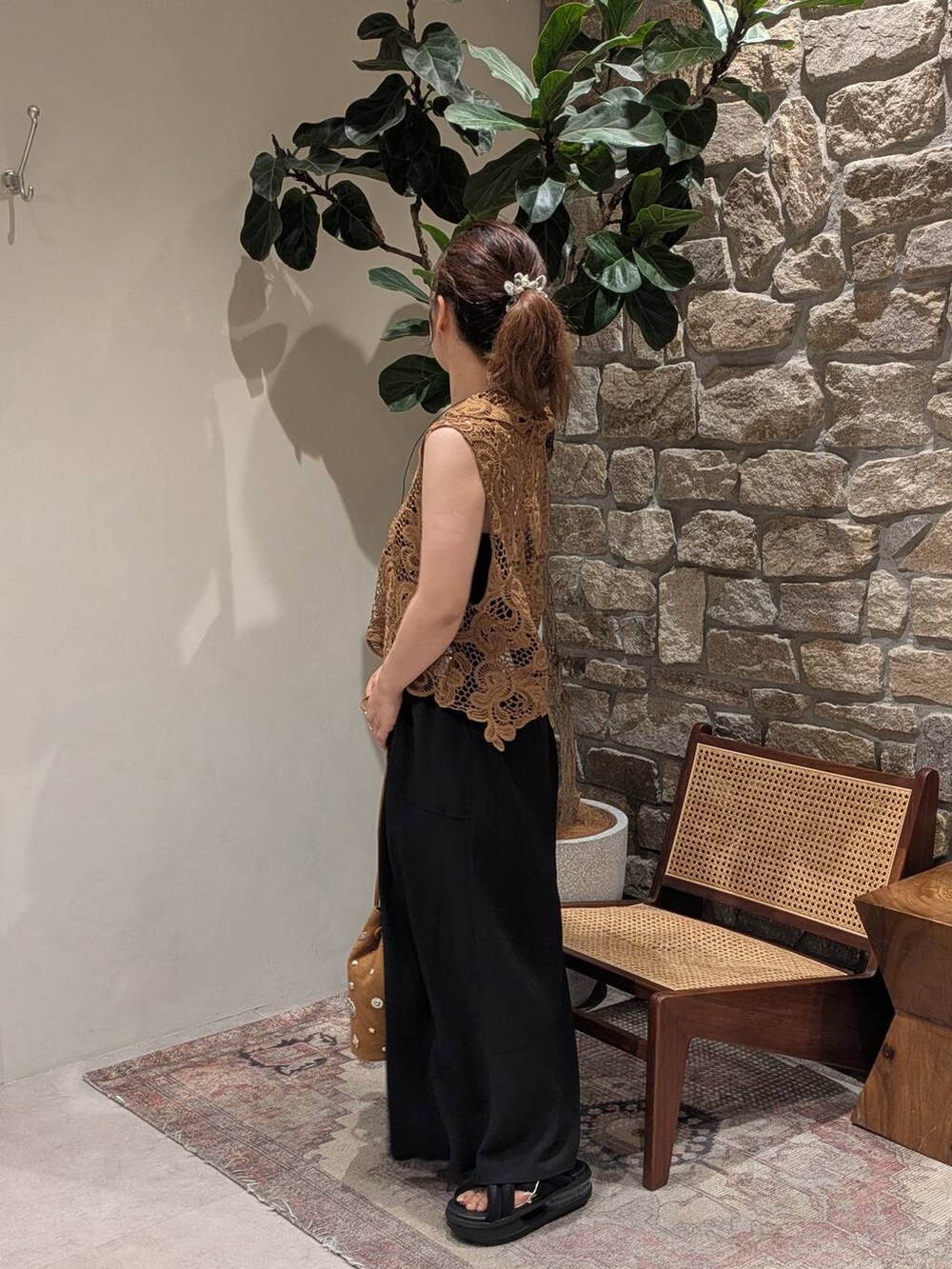 ブラック系のスカート、イエロー系のベスト、シルバー系のネックレスを着用したレディースの夏コーディネートの4枚目の写真