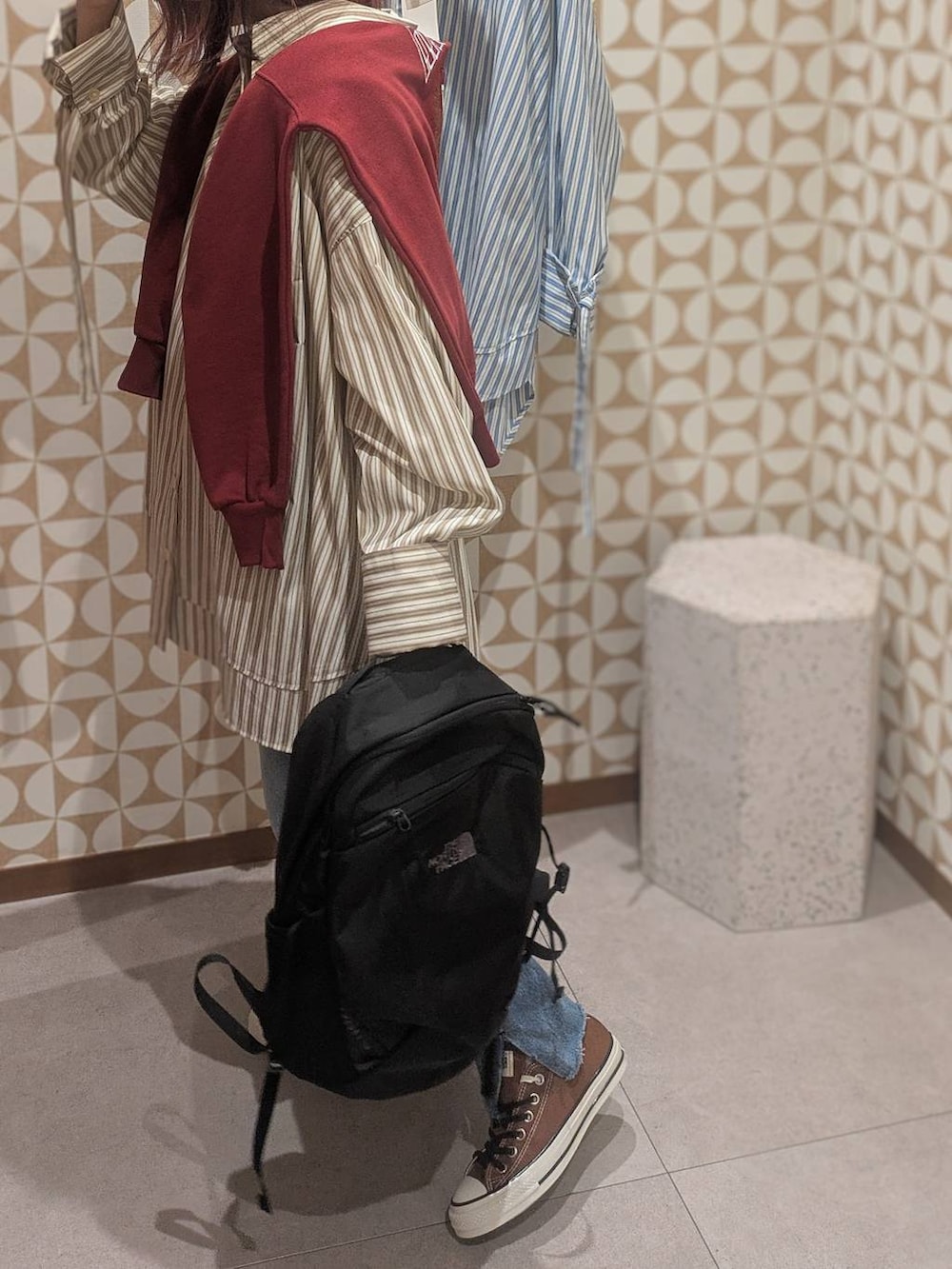 ブラック系のバックパック/リュック、ブルー系のデニムパンツ、レッド系のスウェットを着用したレディースの冬コーディネートの6枚目の写真