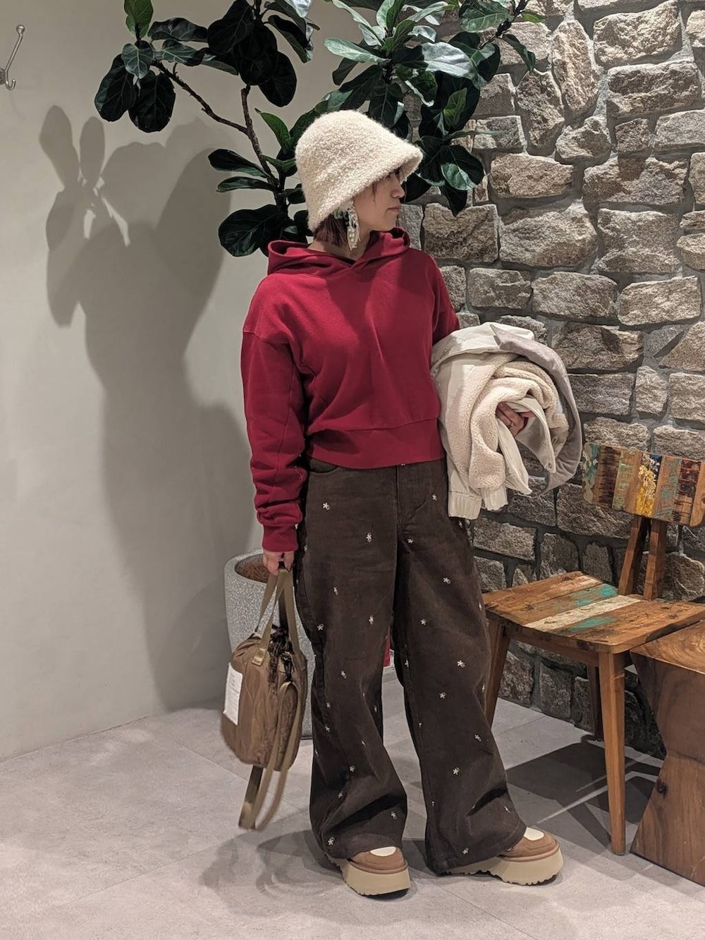 ブラウン系のその他パンツ、レッド系のパーカー、ベージュ系のショルダーバッグを着用したレディースの冬コーディネートの4枚目の写真