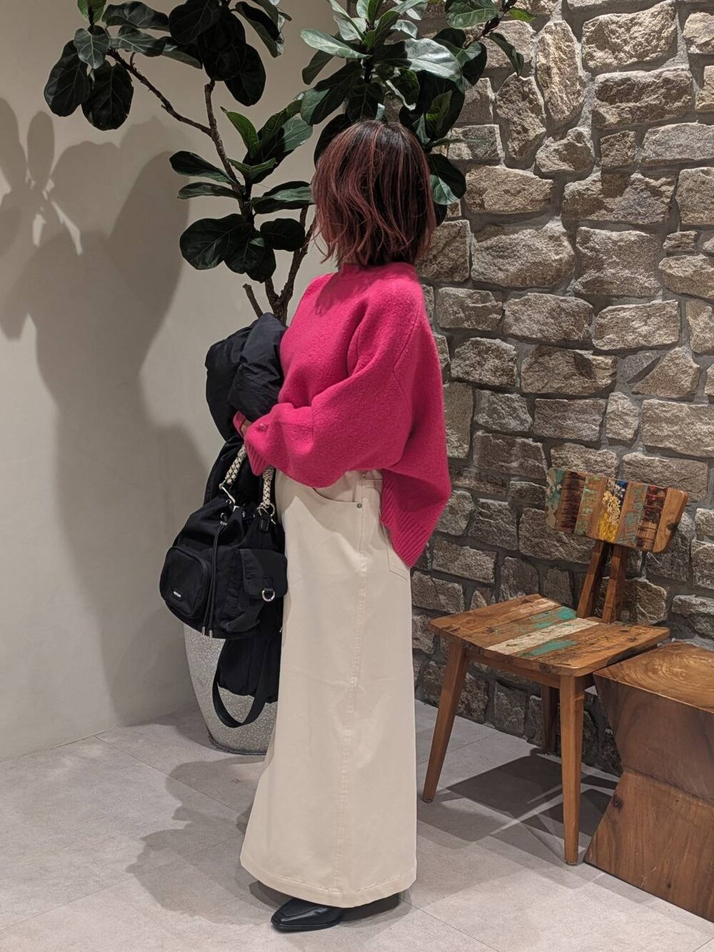 ベージュ系のスカート、ブラック系のブーツ、ブラック系のハンドバッグを着用したレディースの冬コーディネートの3枚目の写真