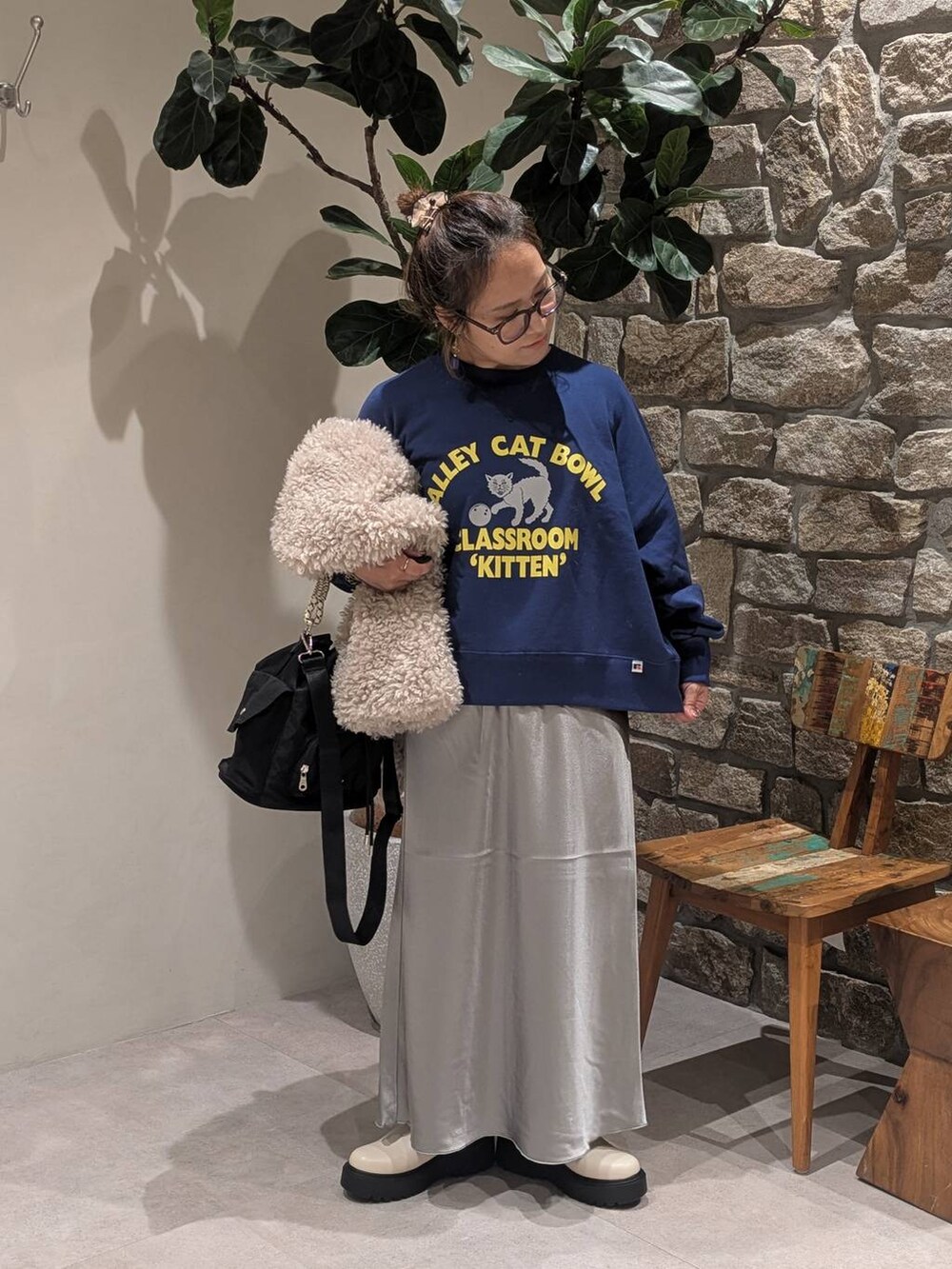 ブルー系のスウェット、ベージュ系のブーツ、ベージュ系のベストを着用したレディースの秋コーディネートの3枚目の写真