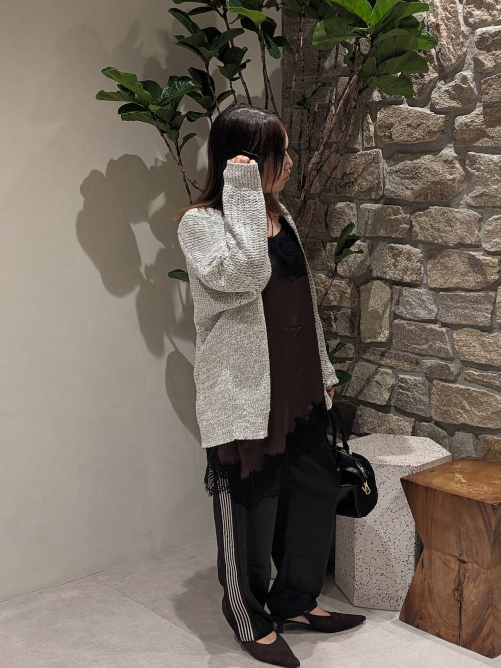 ブラウン系のパンプス、ブラック系のその他パンツ、ホワイト系のカーディガン/ボレロを着用したレディースの秋コーディネートの2枚目の写真