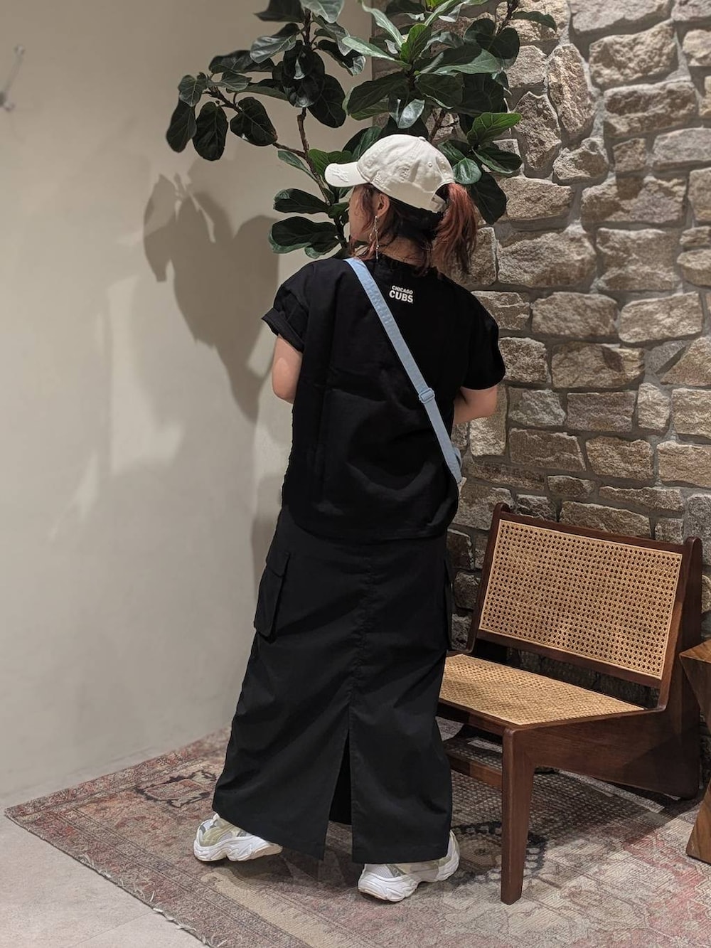 ホワイト系のスニーカー、ベージュ系のショルダーバッグ、ブラック系のスカートを着用したレディースの春コーディネートの2枚目の写真