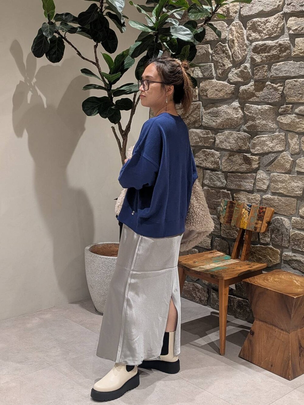 ブルー系のスウェット、ベージュ系のブーツ、ベージュ系のベストを着用したレディースの秋コーディネートの4枚目の写真