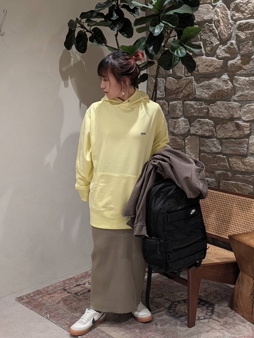 グリーン系のスカート、イエロー系のパーカー、グリーン系のカバーオールを着用したレディースの冬コーディネートの4枚目の写真