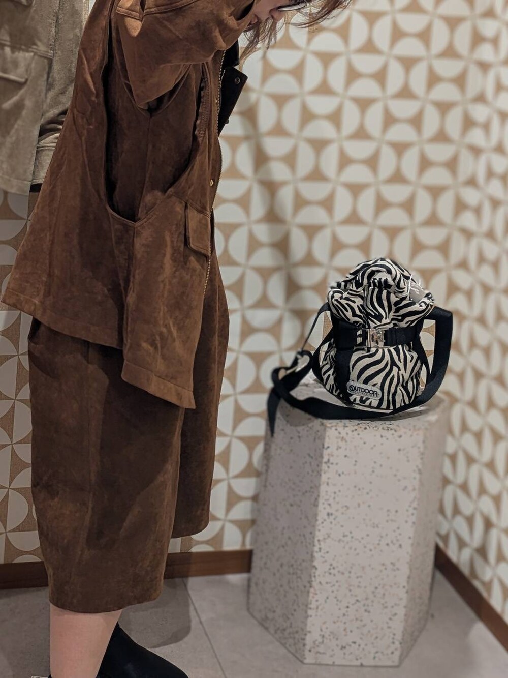 ブラック系のサンダル、ブラウン系のその他パンツ、ブラウン系のブルゾンを着用したレディースの夏コーディネートの3枚目の写真