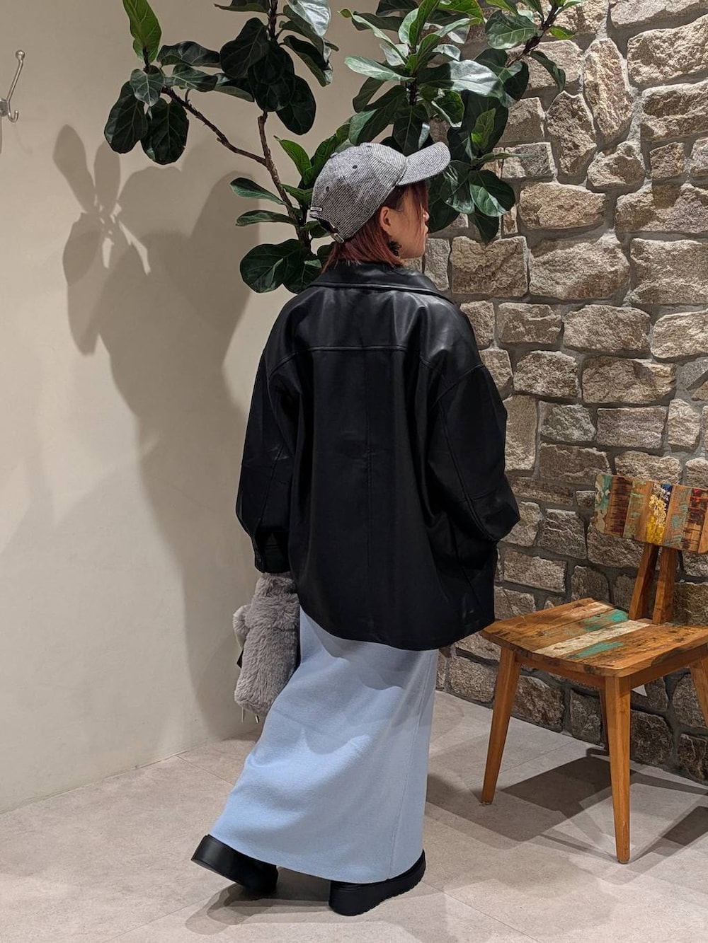 ブラック系のブーツ、ブラック系のブルゾン、グレー系のハンドバッグを着用したレディースの秋コーディネートの2枚目の写真