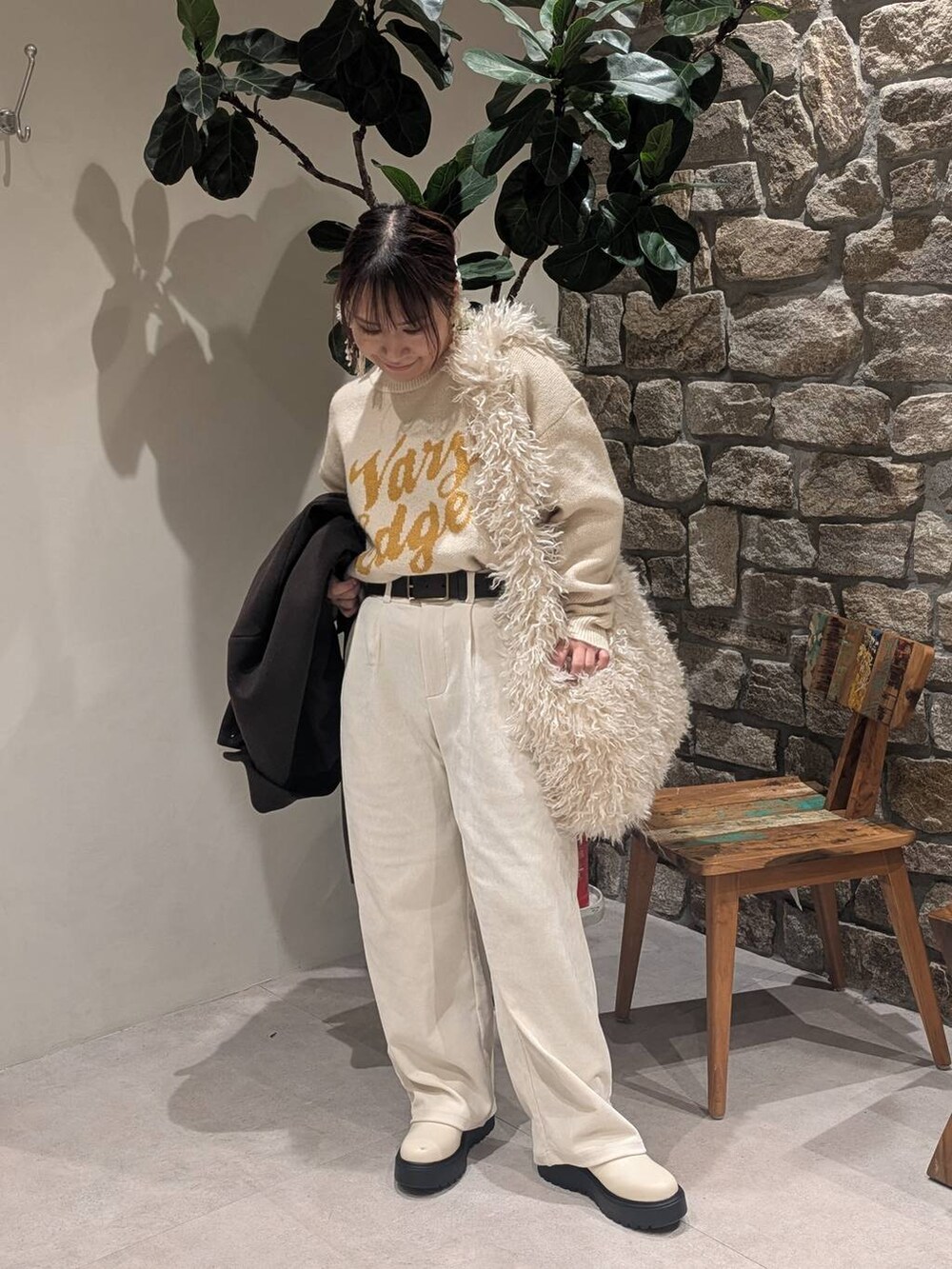 ブラウン系のチェスターコート、ベージュ系のブーツ、ベージュ系のショルダーバッグを着用したレディースの冬コーディネートの5枚目の写真