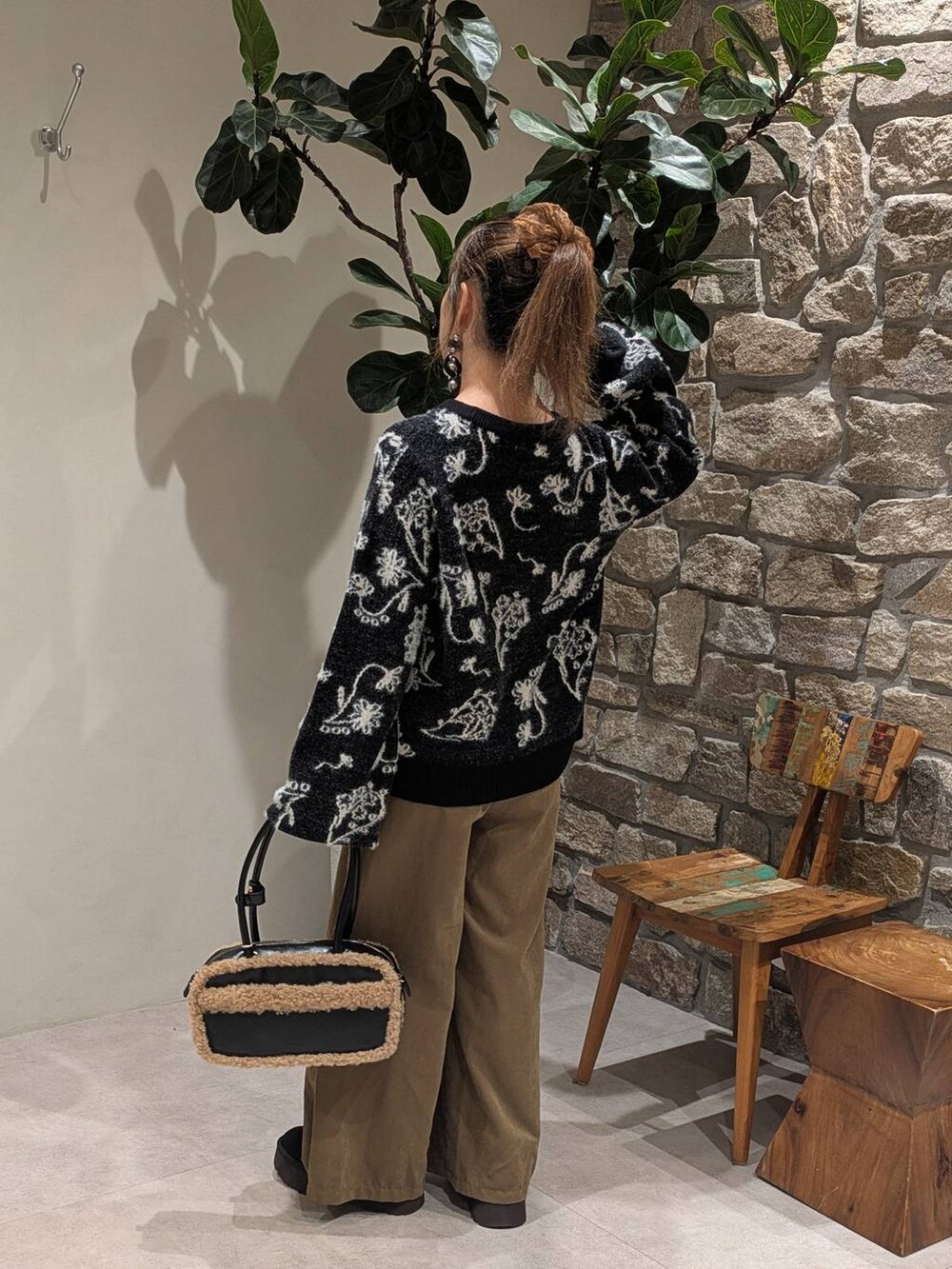 ブラック系のハンドバッグ、グリーン系のその他パンツ、ブラック系のニット/セーターを着用したレディースの秋コーディネートの3枚目の写真