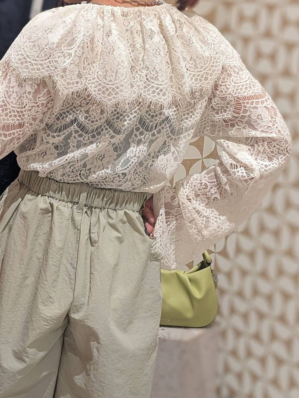 グリーン系のハンドバッグ、ホワイト系のローファー、グレー系のその他パンツを着用したレディースの冬コーディネートの5枚目の写真