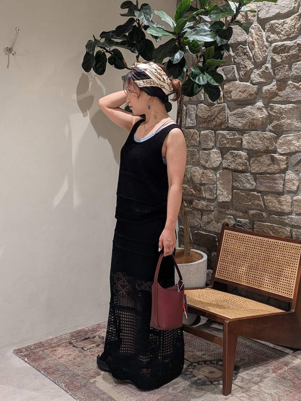 ブルー系のキャミソール、レッド系のハンドバッグ、ブラック系のスカートを着用したレディースの夏コーディネートの3枚目の写真