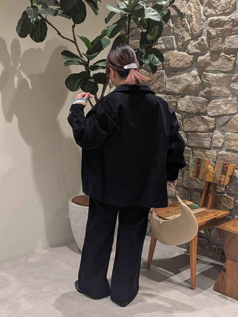 ベージュ系のハンドバッグ、ブラック系のブーツ、ホワイト系のニット/セーターを着用したレディースの冬コーディネートの2枚目の写真