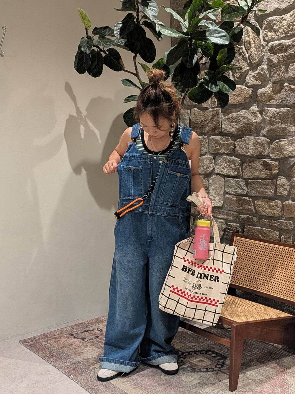 ブラック系のトートバッグ、ベージュ系のスニーカー、グリーン系のTシャツ/カットソーを着用したレディースの夏コーディネートの2枚目の写真