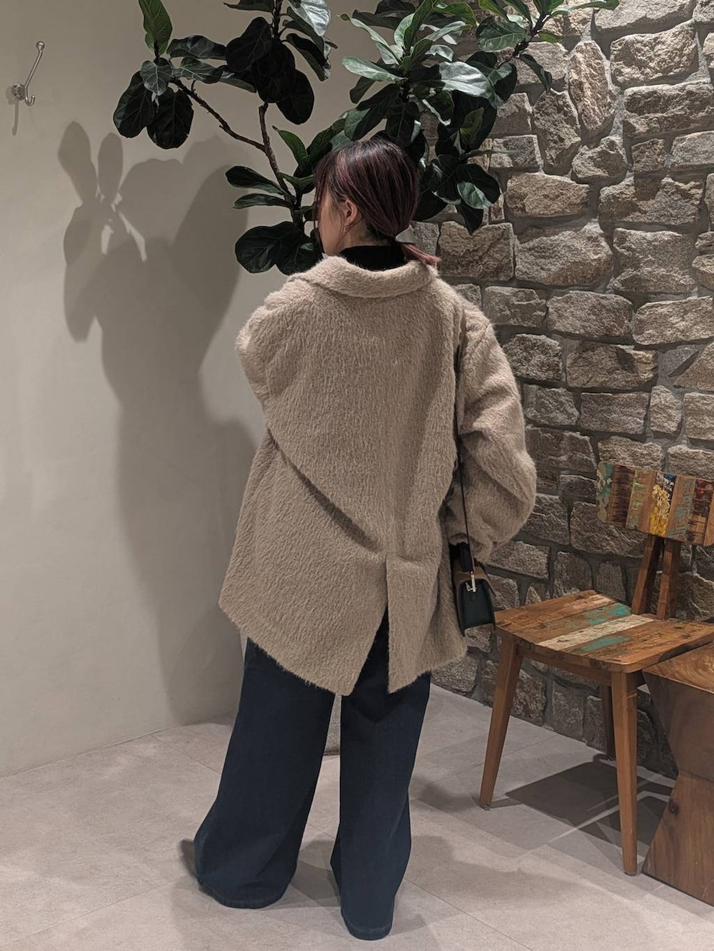 ブルー系のデニムパンツ、その他のブーツ、ブラック系のニット/セーターを着用したレディースの冬コーディネートの3枚目の写真