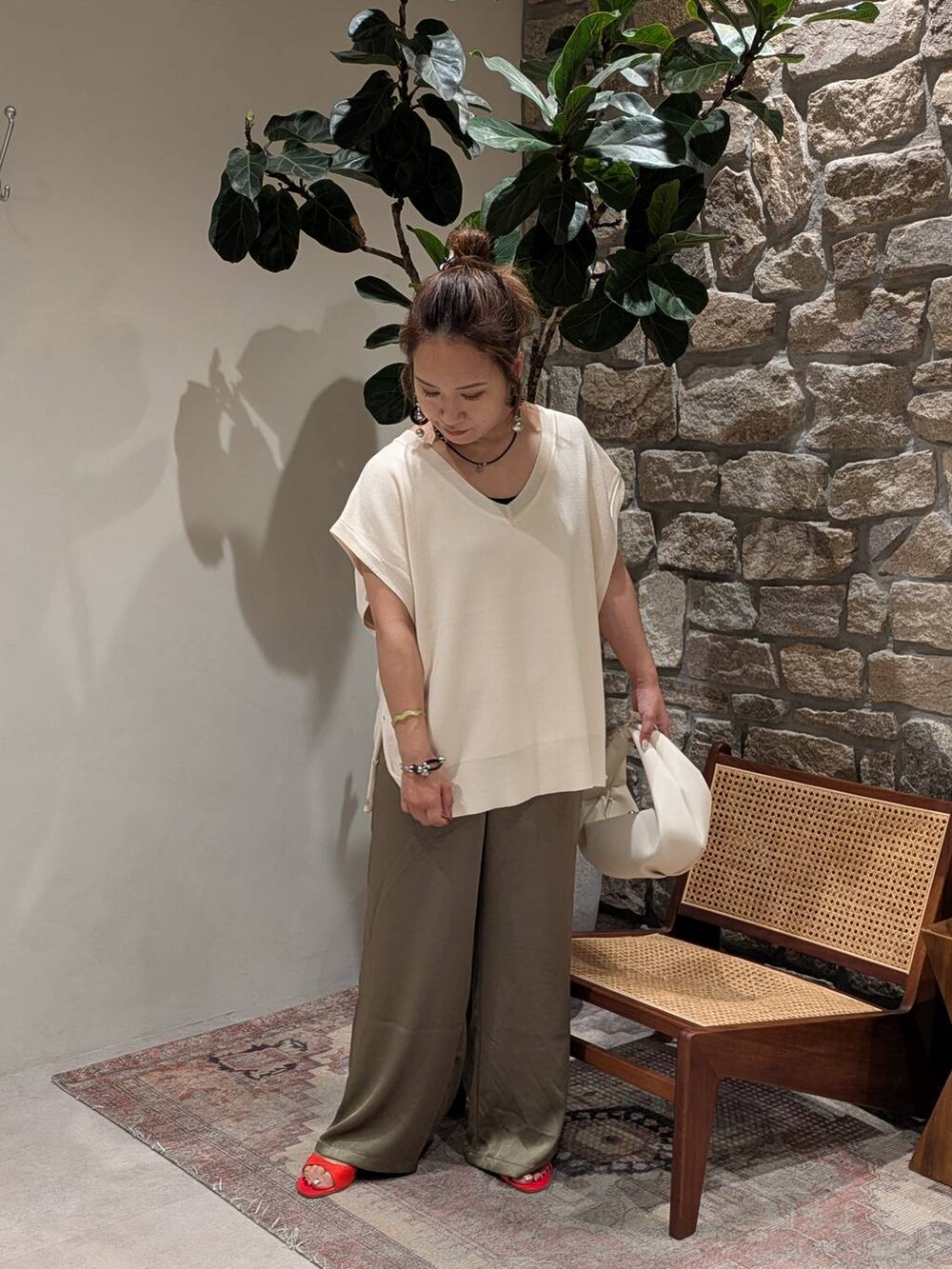 レッド系のサンダル、ベージュ系のハンドバッグ、グリーン系のその他パンツを着用したレディースの夏コーディネートの2枚目の写真