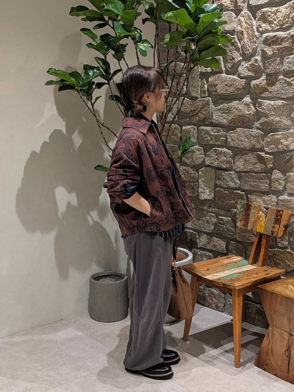 ブラウン系のブルゾン、ブラウン系のハンドバッグ、グレー系のスウェットパンツを着用したレディースの秋コーディネートの3枚目の写真