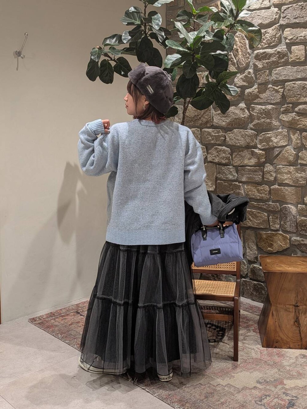 グレー系のデニムジャケット、ブルー系のニット/セーター、グレー系のスニーカーを着用したレディースの冬コーディネートの4枚目の写真