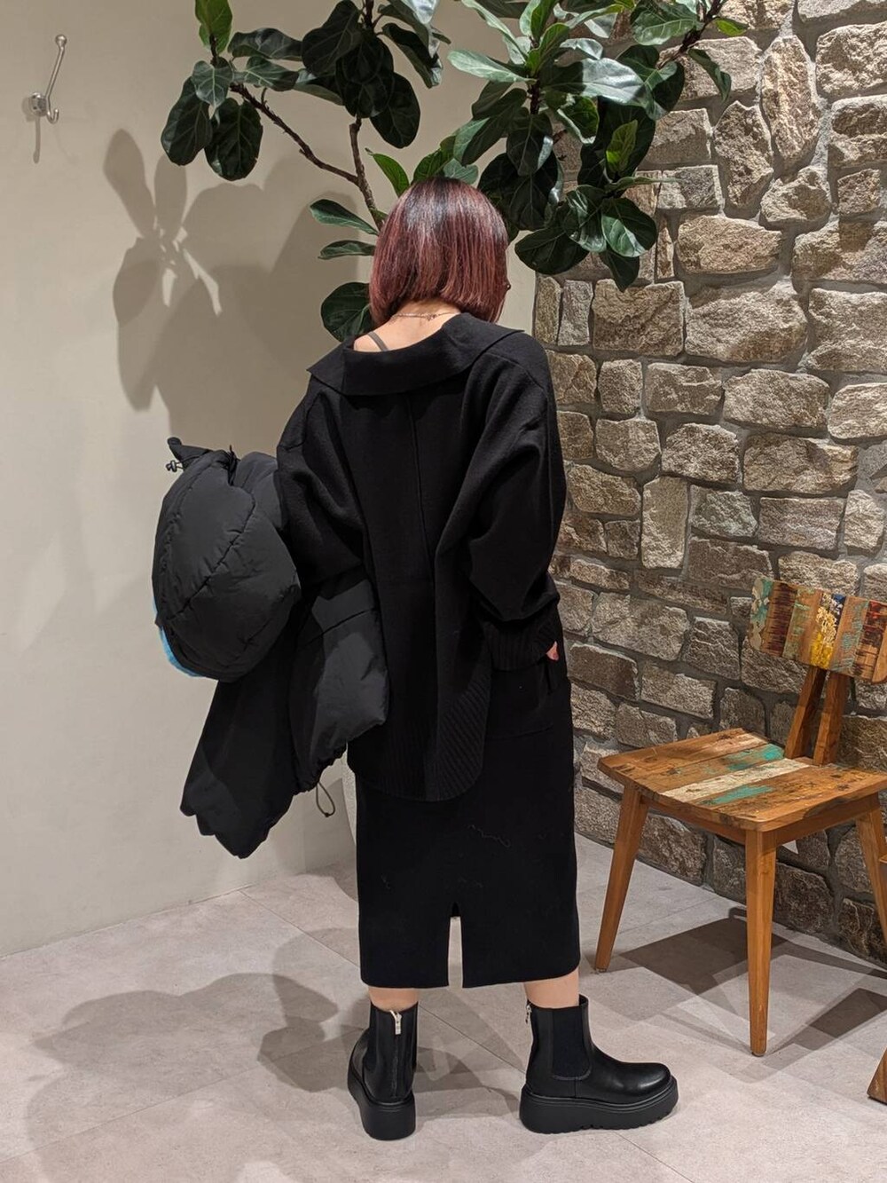 ブラック系のブーツ、ブラック系のその他アウター、ブラック系のニット/セーターを着用したレディースの秋コーディネートの4枚目の写真