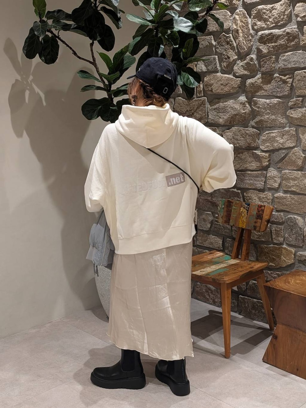 ブラック系のブーツ、ブラック系のショルダーバッグ、ホワイト系のパーカーを着用したレディースの秋コーディネートの5枚目の写真