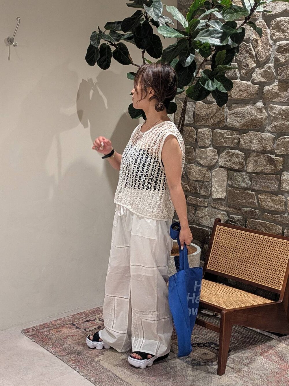 ブルー系のエコバッグ/サブバッグ、ホワイト系のベスト、ホワイト系のその他パンツを着用したレディースの夏コーディネートの2枚目の写真