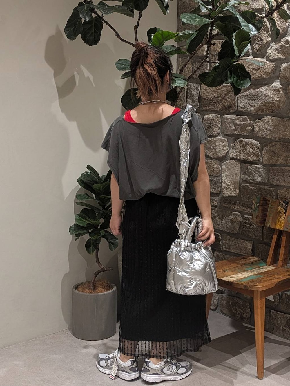 グレー系のスニーカー、レッド系のタンクトップ、シルバー系のショルダーバッグを着用したレディースの夏コーディネートの3枚目の写真