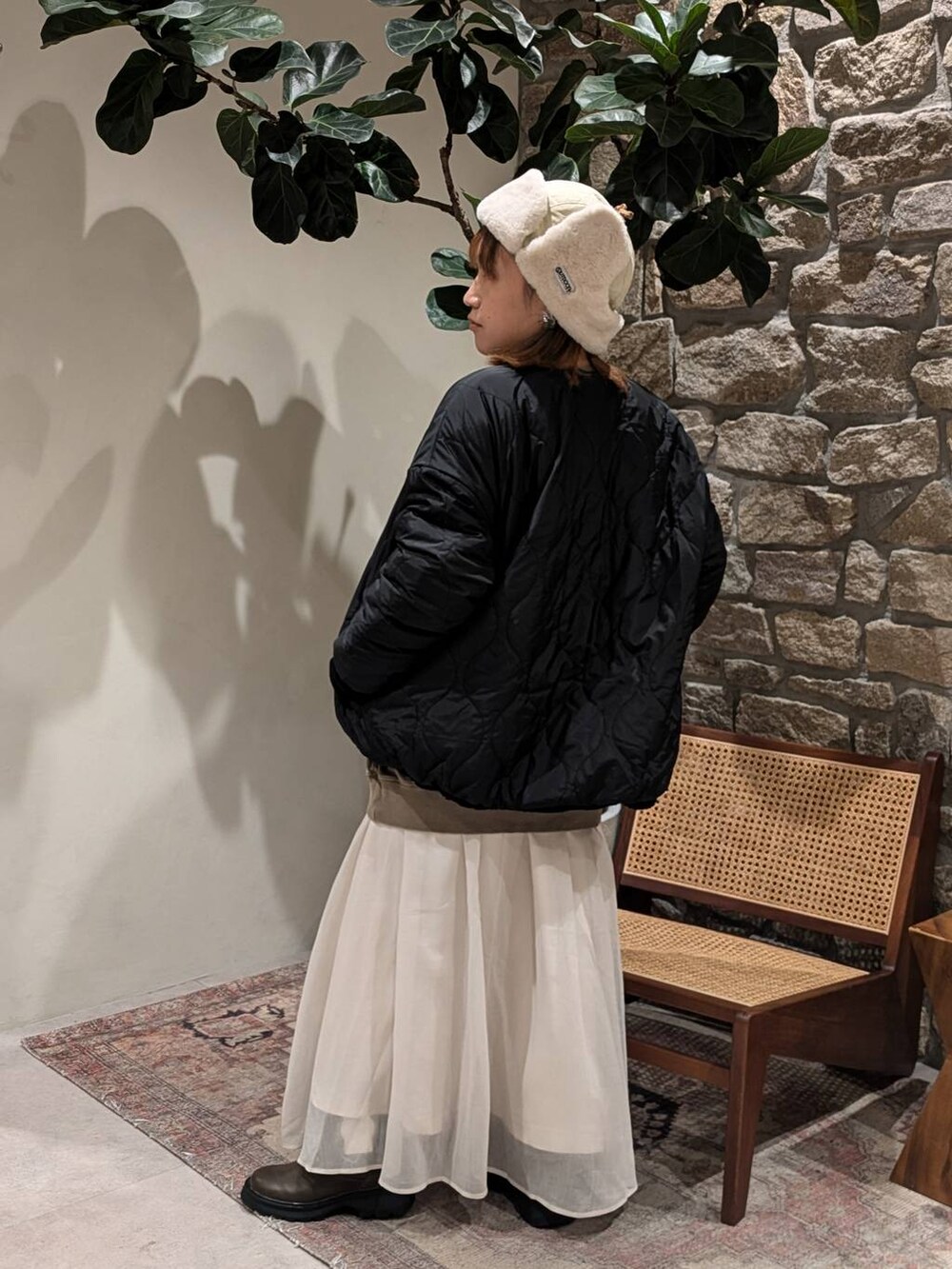 ブラック系のブルゾン、ブラウン系のブーツ、ブラウン系のスウェットを着用したレディースの秋コーディネートの2枚目の写真