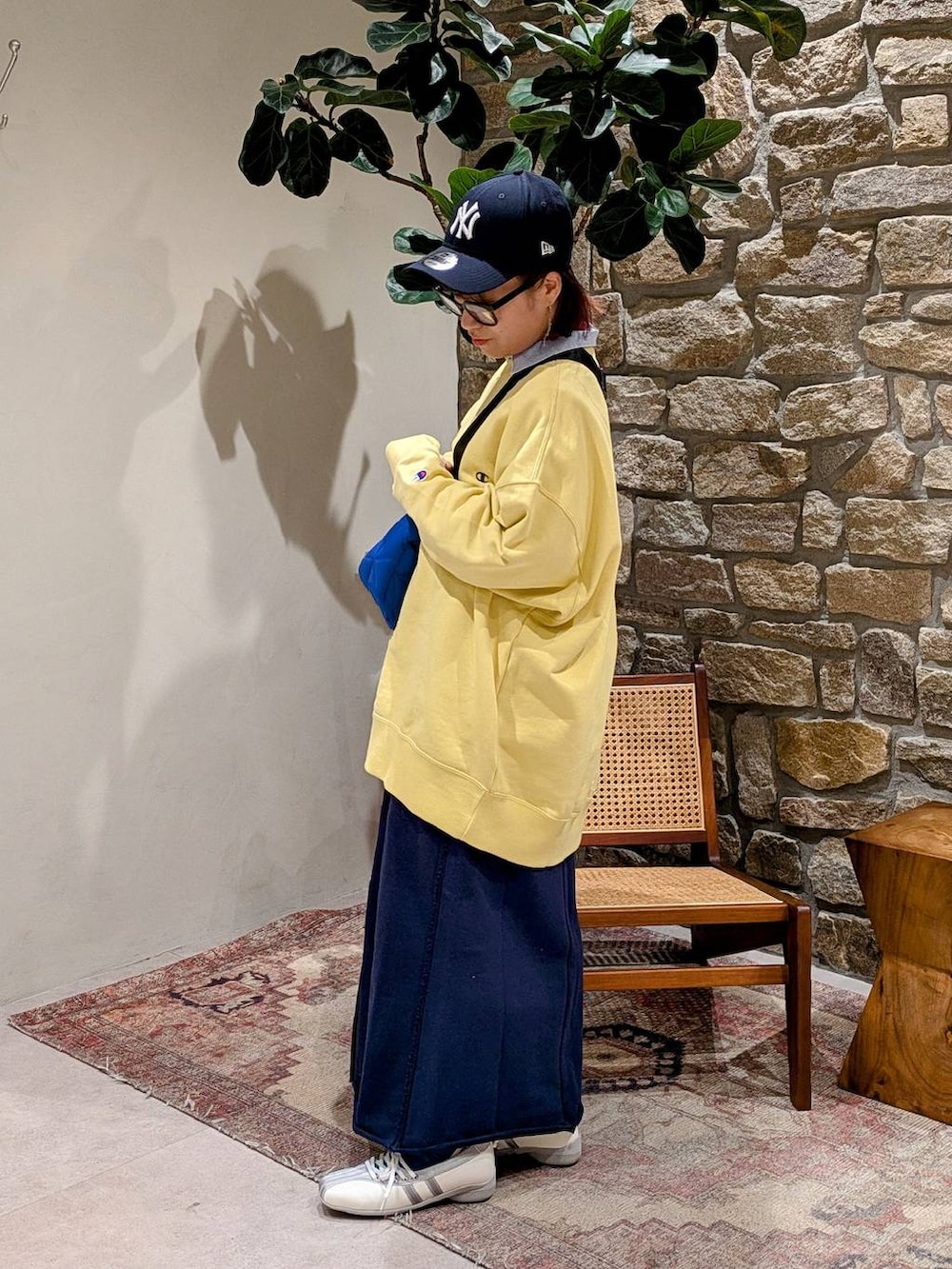 ブルー系のショルダーバッグ、イエロー系のスウェット、ブルー系のスカートを着用したレディースの冬コーディネートの2枚目の写真