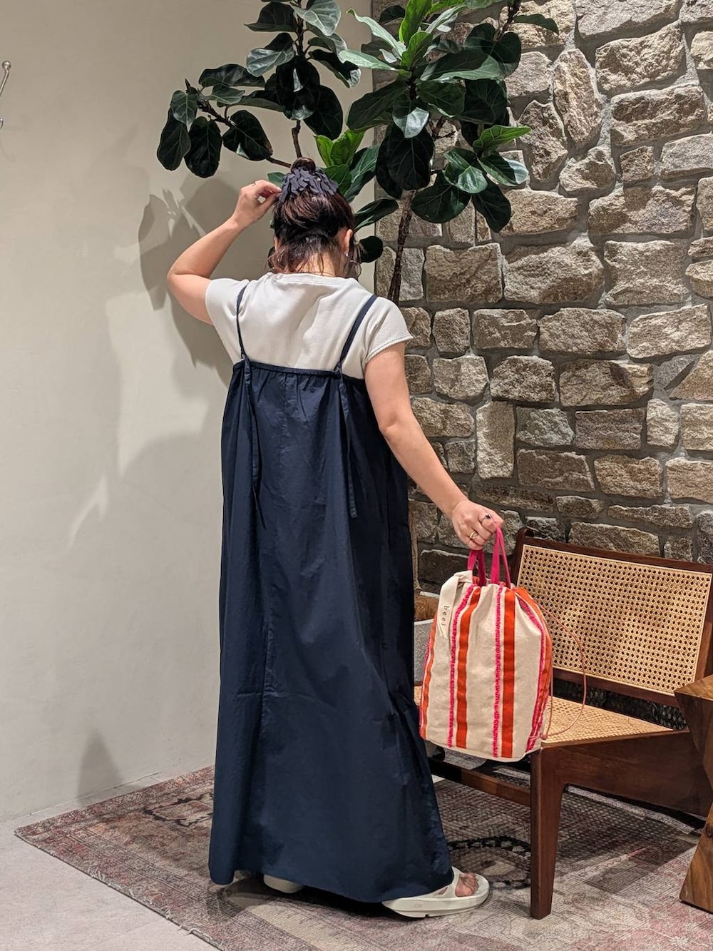 ピンク系のハンドバッグ、グレー系のサンダル、ブルー系のジャンパースカートを着用したレディースの春コーディネートの2枚目の写真