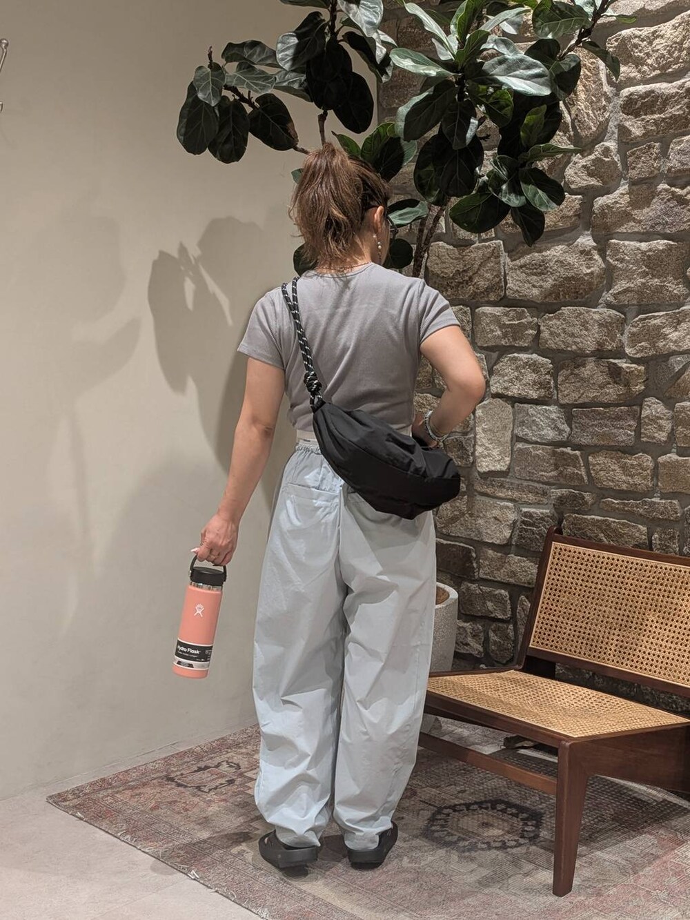 ブラック系のショルダーバッグ、グレー系のTシャツ/カットソー、ブラック系のサンダルを着用したレディースの夏コーディネートの2枚目の写真