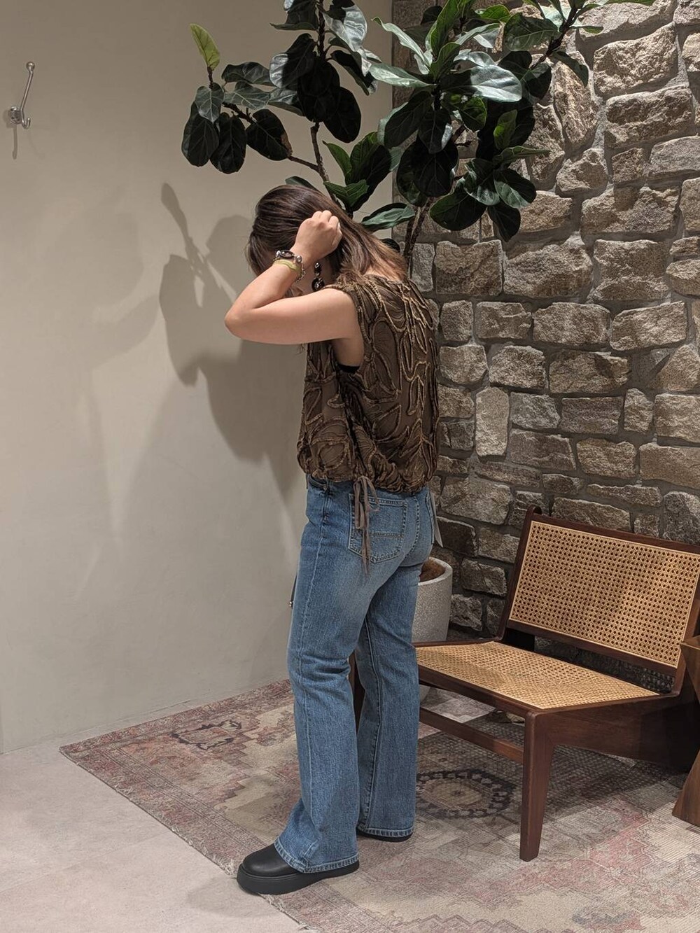 ブラック系のハンドバッグ、ブルー系のデニムパンツ、ブラック系のサンダルを着用したレディースの夏コーディネートの2枚目の写真