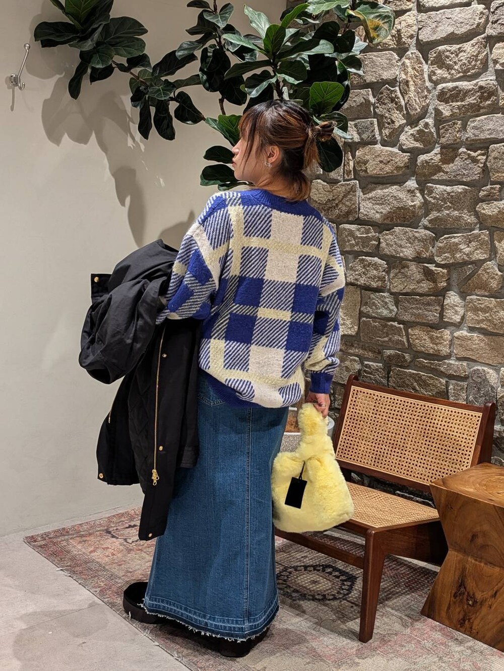 ブルー系のデニムスカート、イエロー系のハンドバッグ、ブルー系のニット/セーターを着用したレディースの冬コーディネートの4枚目の写真