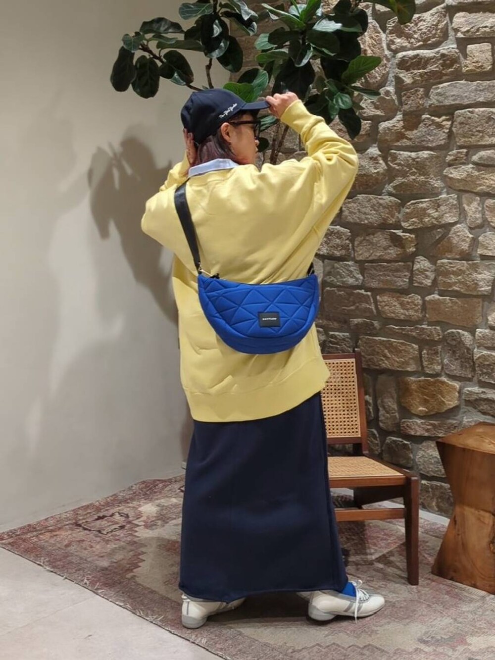 ブルー系のショルダーバッグ、イエロー系のスウェット、ブルー系のスカートを着用したレディースの冬コーディネートの3枚目の写真