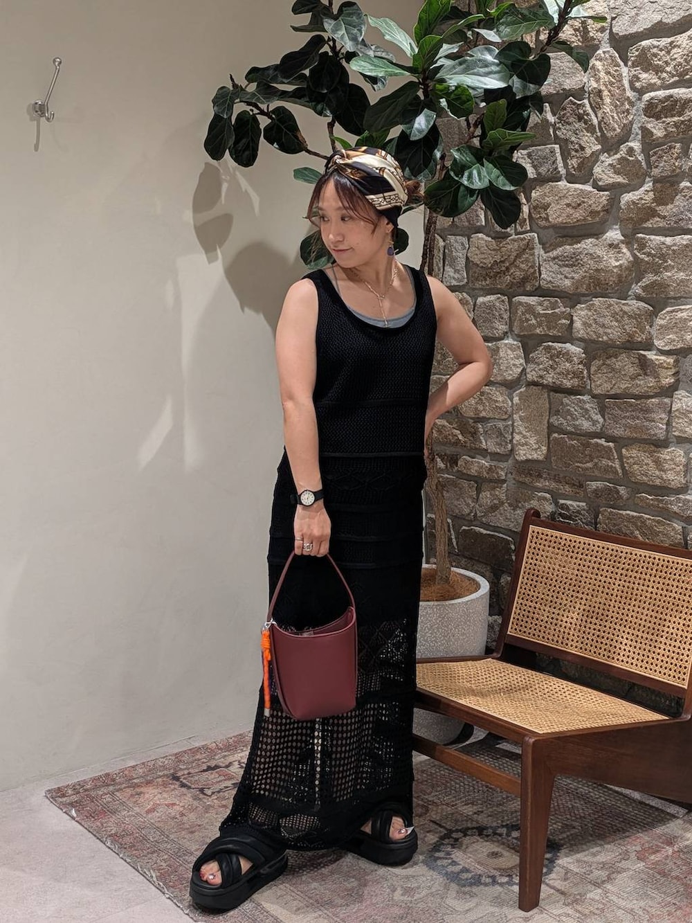 ブルー系のキャミソール、レッド系のハンドバッグ、ブラック系のスカートを着用したレディースの夏コーディネートの2枚目の写真