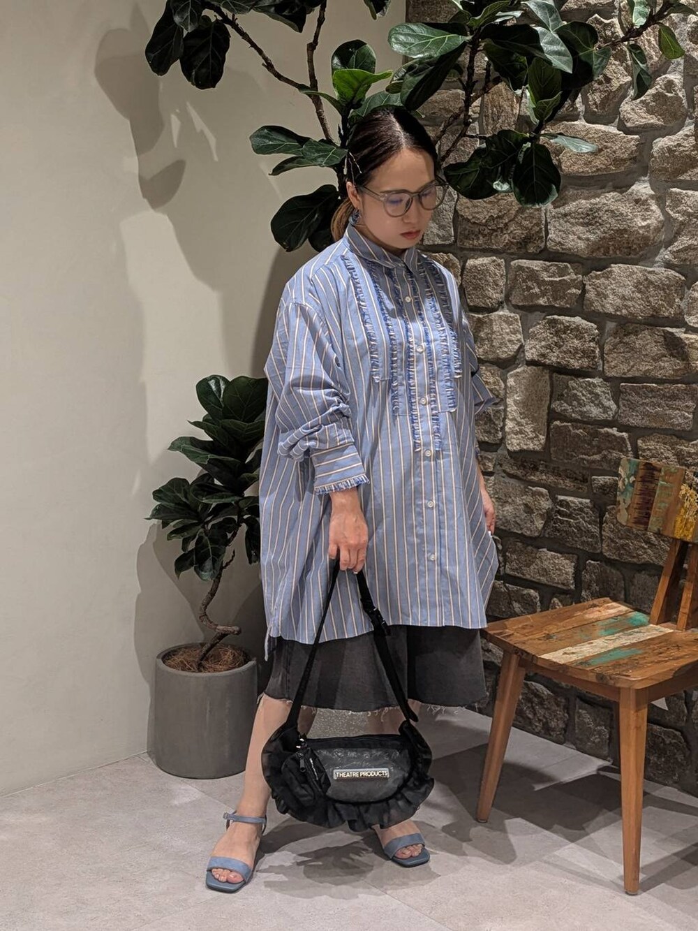 ブルー系のチュニック、ブルー系のサンダル、ブラック系のショルダーバッグを着用したレディースの夏コーディネートの2枚目の写真