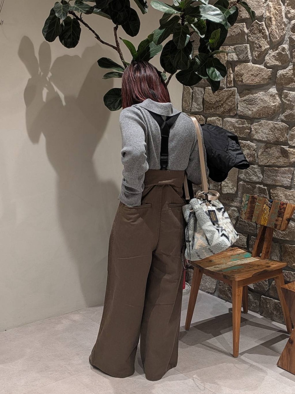 ブラウン系のスニーカー、グレー系のハンドバッグ、ブラック系のブルゾンを着用したレディースの冬コーディネートの3枚目の写真