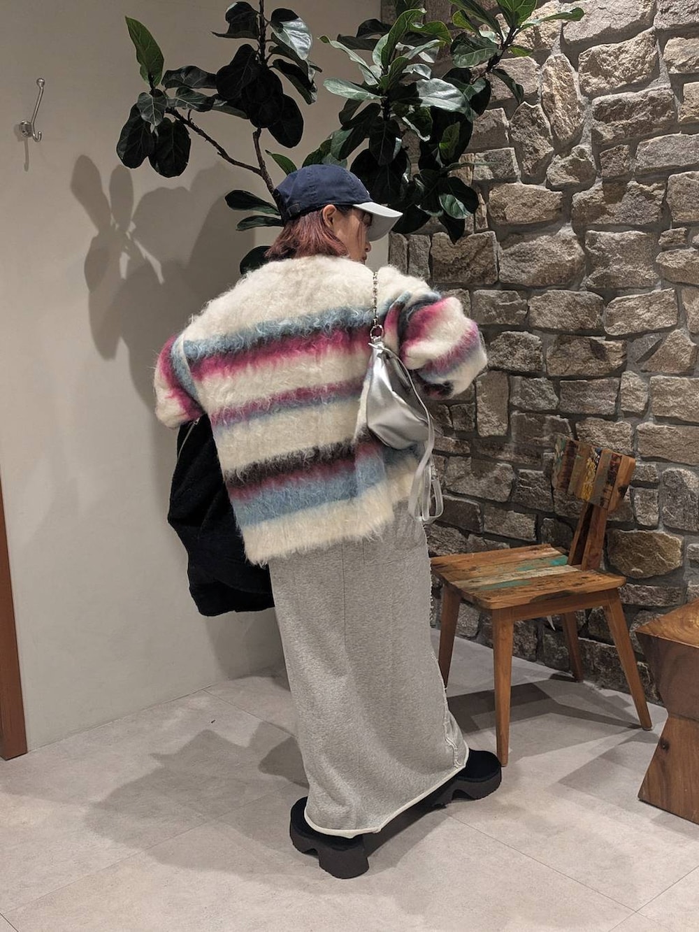 グレー系のその他アウター、シルバー系のハンドバッグ、ホワイト系のニット/セーターを着用したレディースの冬コーディネートの2枚目の写真